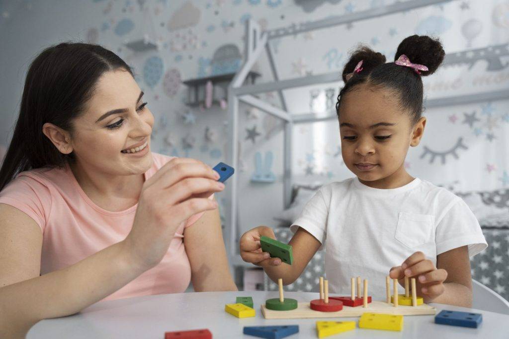 Psicóloga utilizando brinquedos em sua sessão de terapia com uma criança.